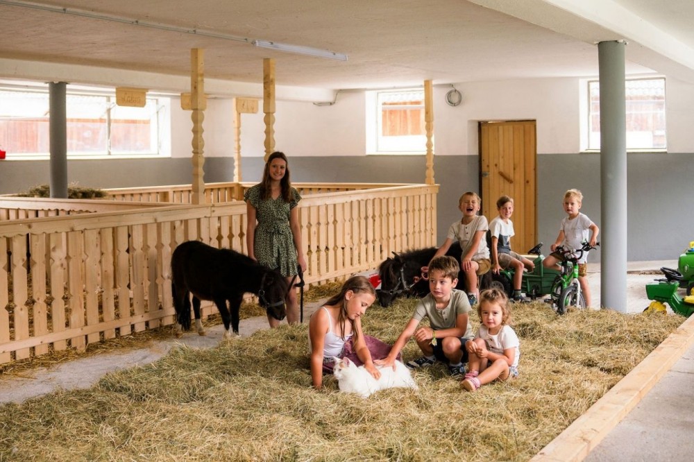 Kinder helfen fleißig im Kleintierstall